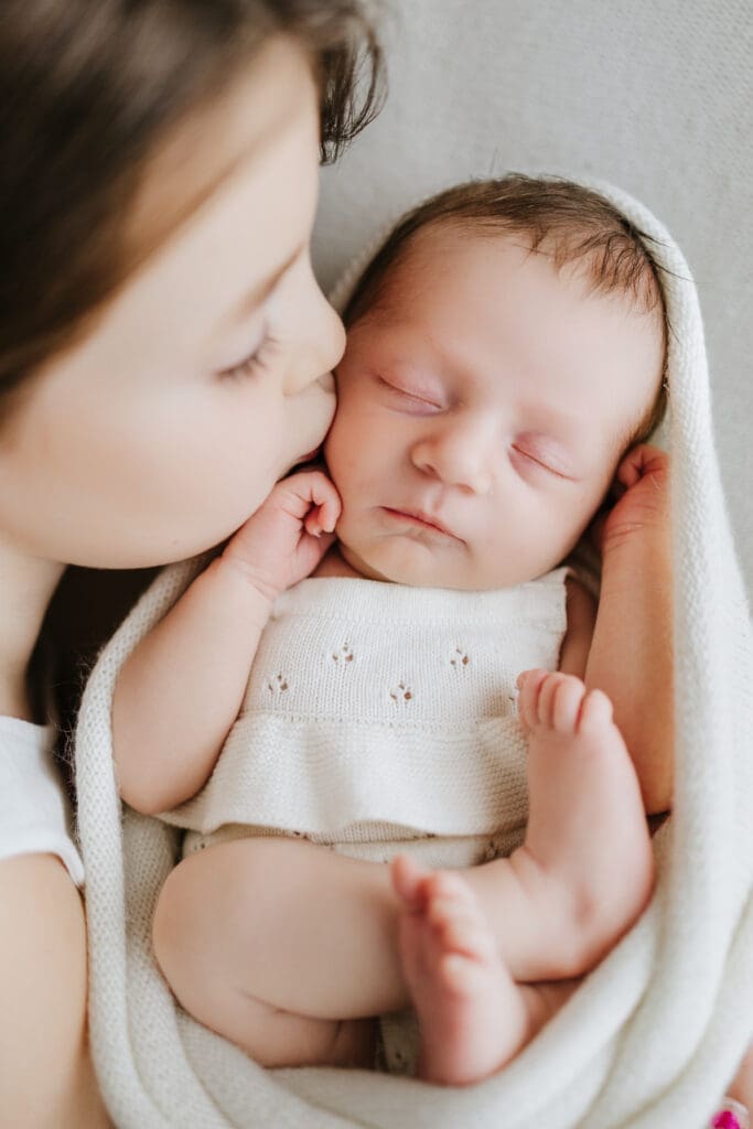 Parents cuddling their newborn during a relaxed Louisville newborn photography session.