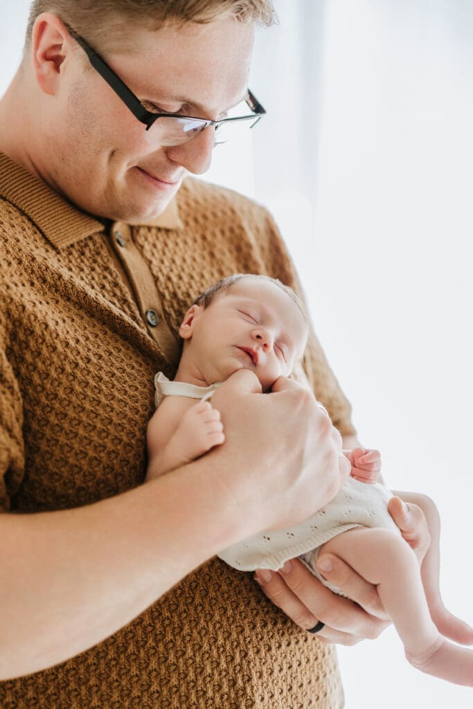 Parents cuddling their newborn during a relaxed Louisville newborn photography session.