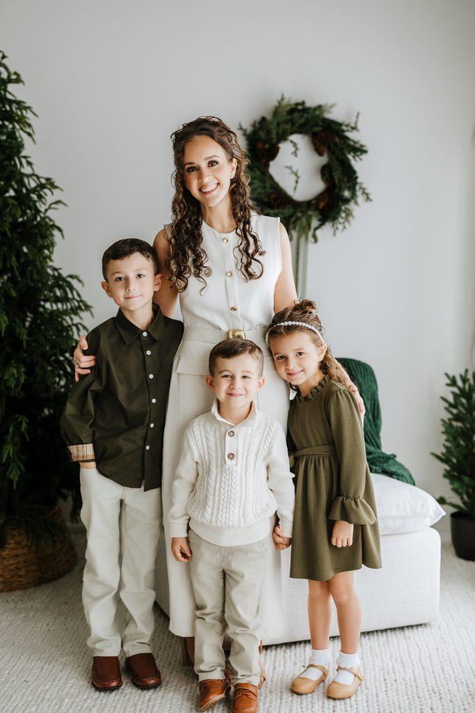 Family cuddling on neutral seating during a Christmas mini session in Louisville, KY