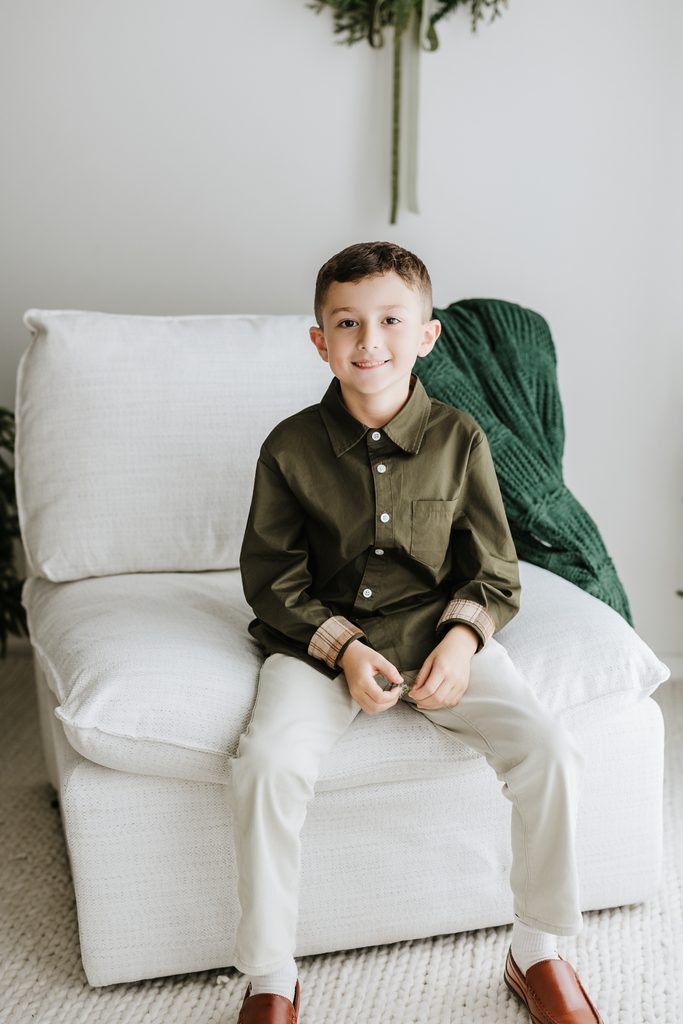 Family cuddling on neutral seating during a Christmas mini session in Louisville, KY