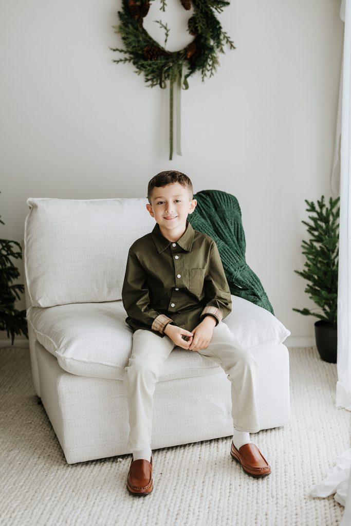 Family cuddling on neutral seating during a Christmas mini session in Louisville, KY