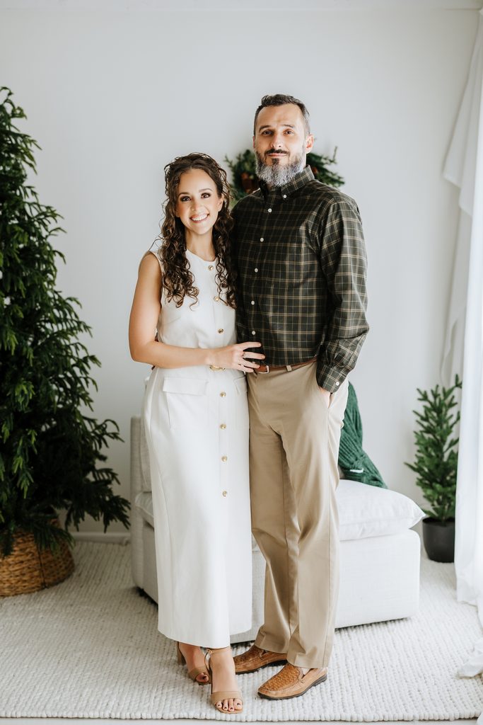 Family cuddling on neutral seating during a Christmas mini session in Louisville, KY